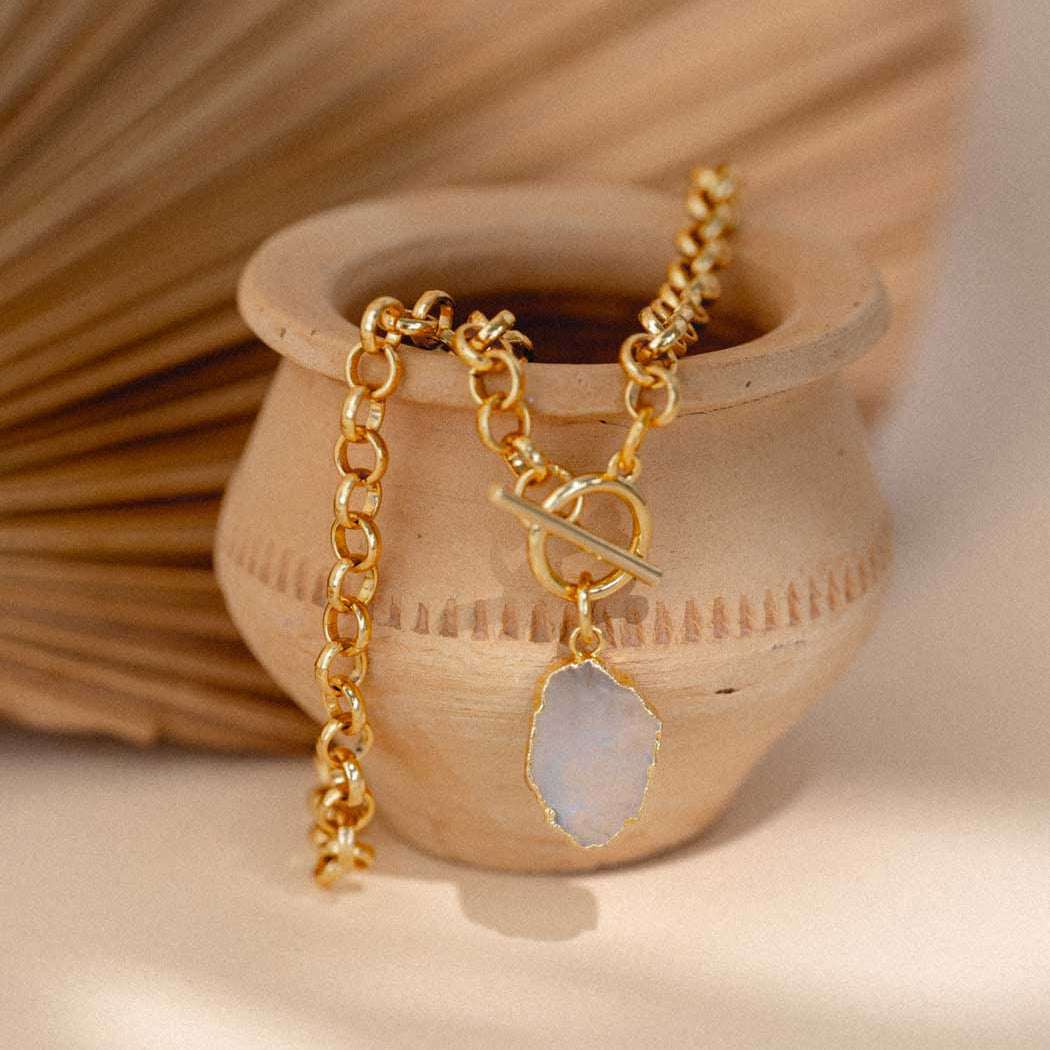 Gold necklace with a pendant on a wooden surface