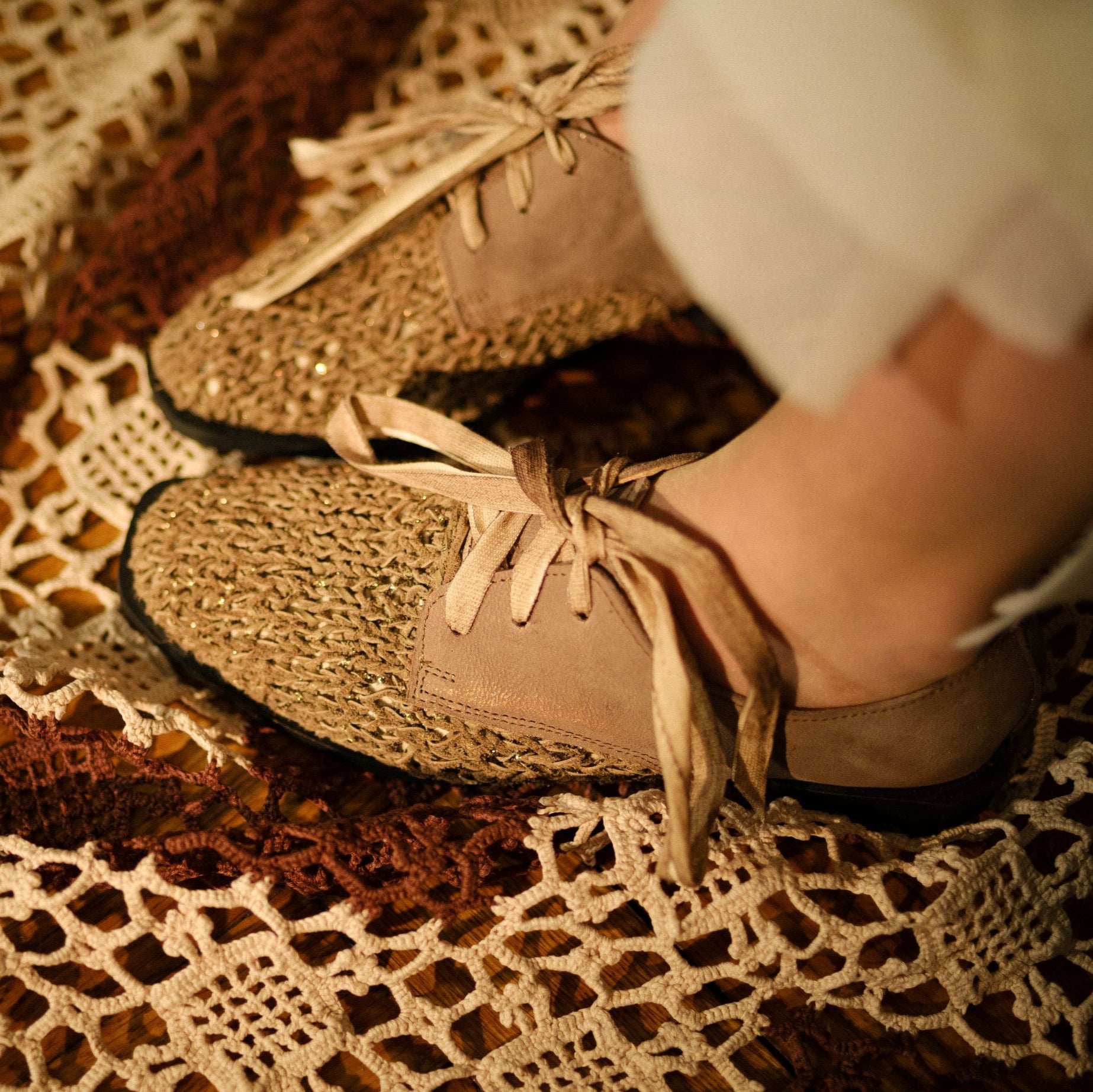 Pair of beige knit and suede lace-up shoes with light beige laces.