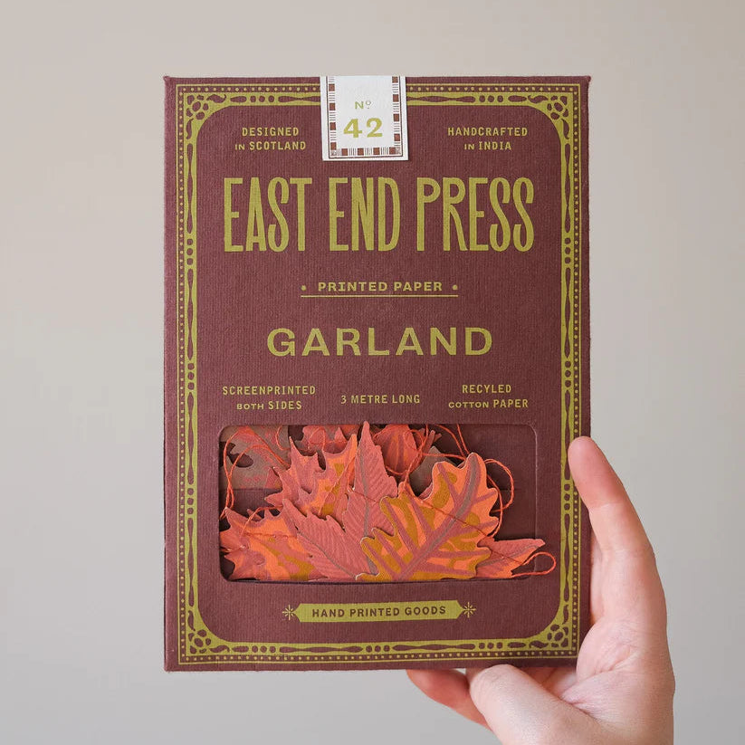 East End Press 3-meter garland in a maroon box.  Features screen-printed orange and red leaf shapes on recycled cotton paper.