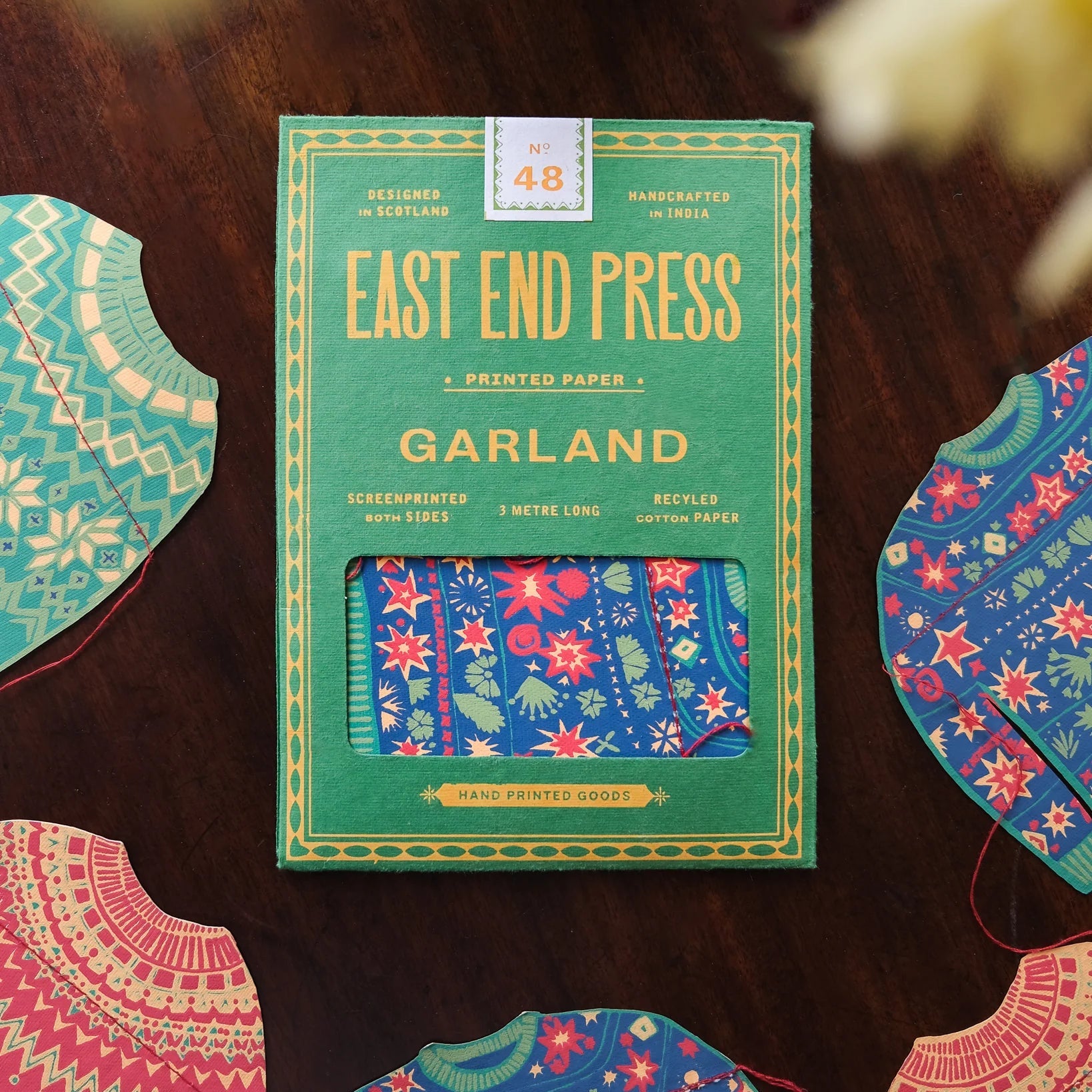 Packaging of East End Press Garland printed paper with decorative paper pieces on a wooden surface.