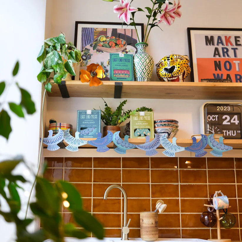 Shelving unit with decorative items above a kitchen sink