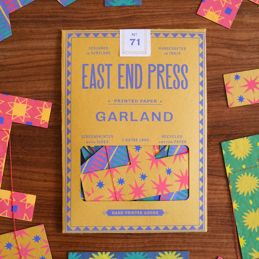 Box of East End Press Garland printed paper with colorful letter cutouts on a wooden surface