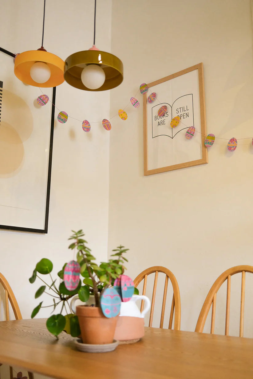 Dining area with wooden table, chairs, and decorative elements on the wall.