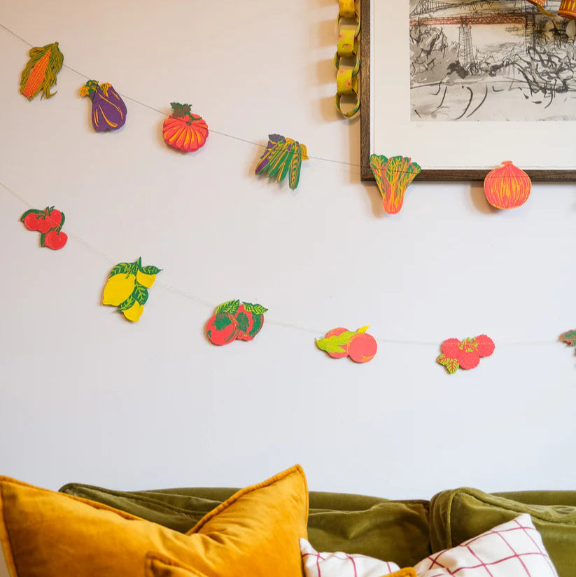 Colorful fruit and vegetable garland with string, featuring illustrations of corn, eggplant, pumpkin, chard, onion,