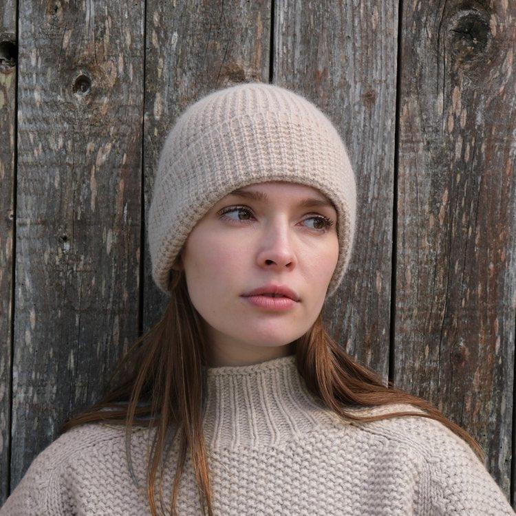 A light beige ribbed knit beanie.