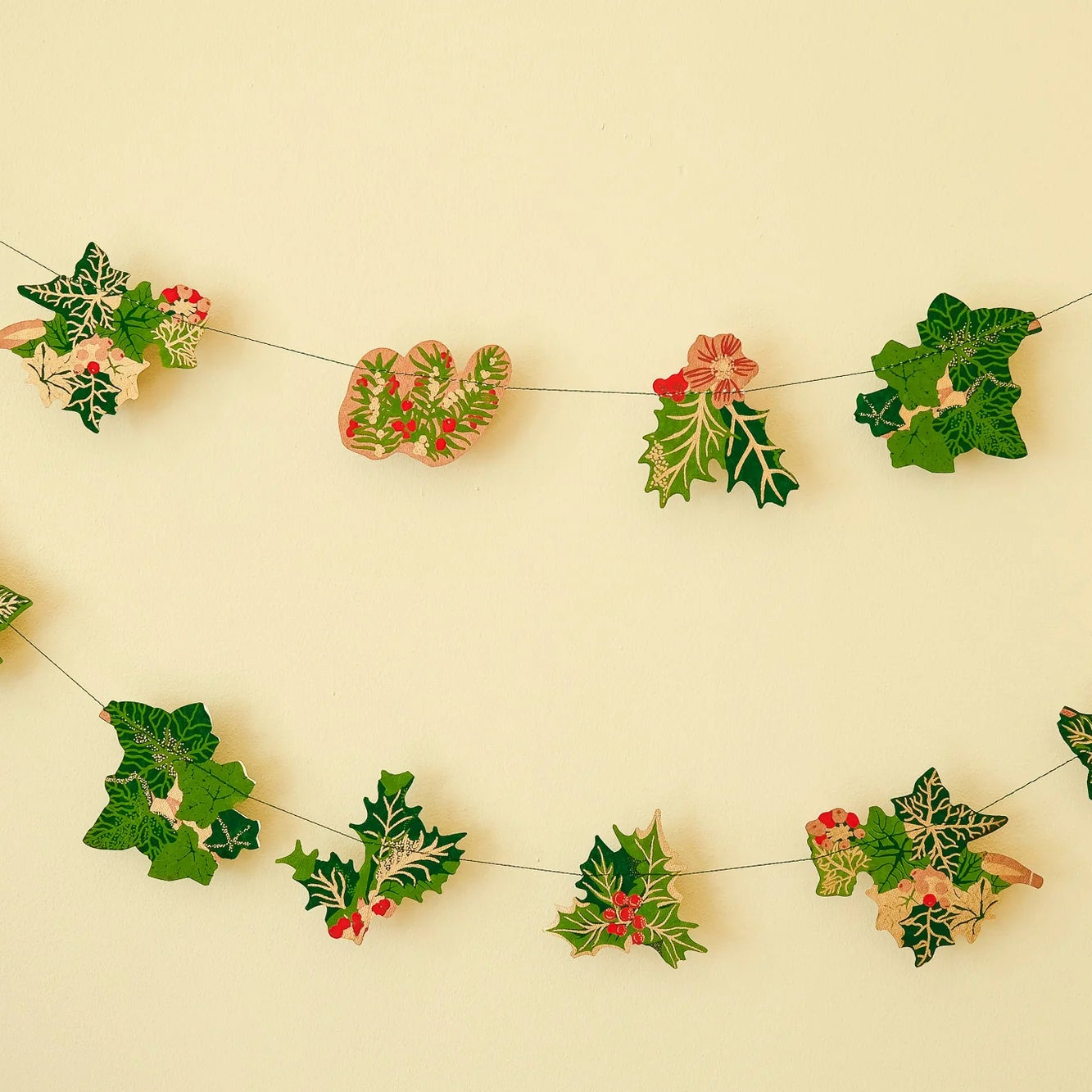 Decorative holly berry garland on a beige background