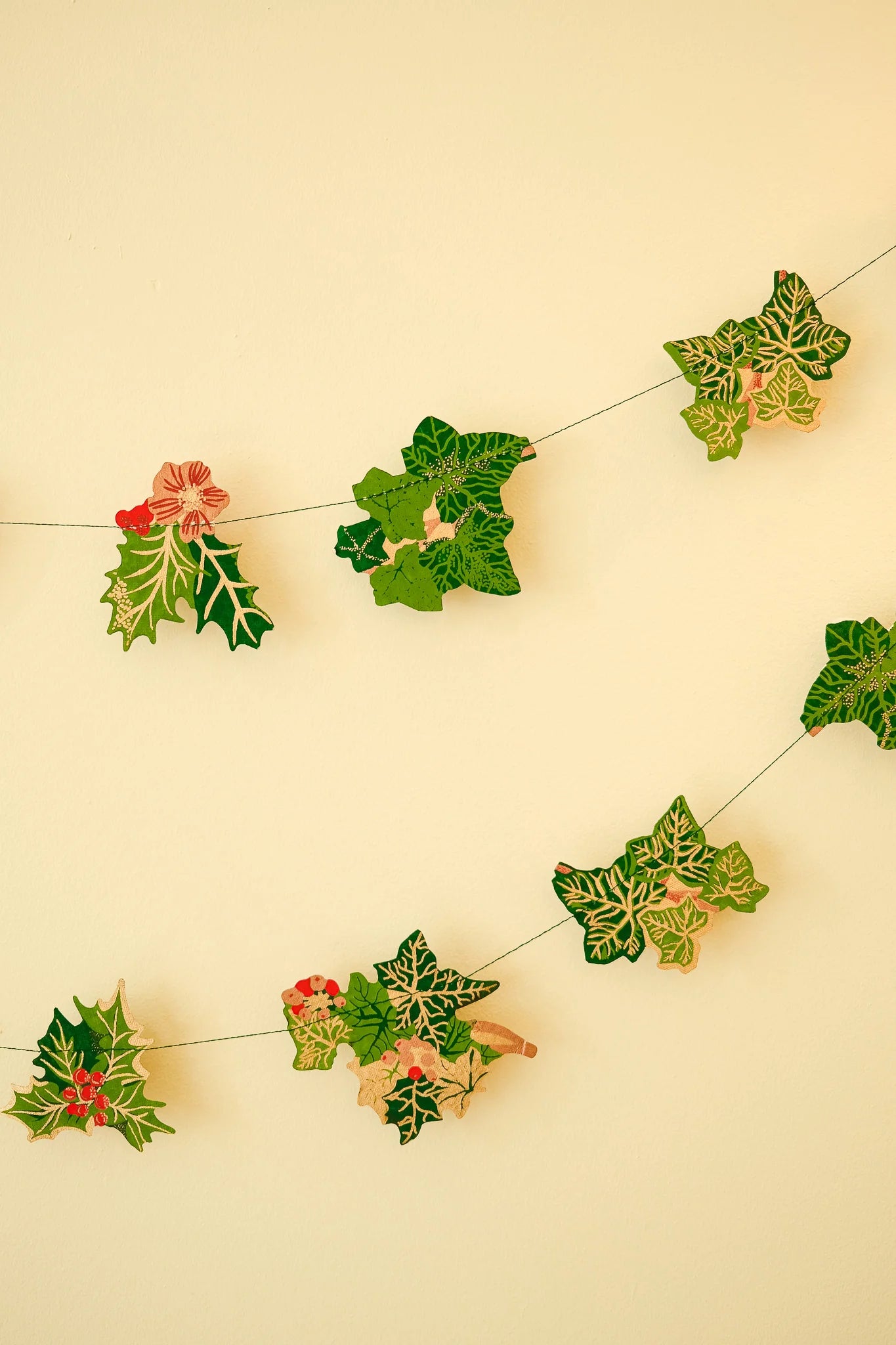 Decorative holly leaf garland on a beige background
