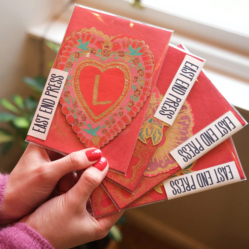 Stack of East End Press cards featuring ornate heart designs; one heart includes a gold letter L.
