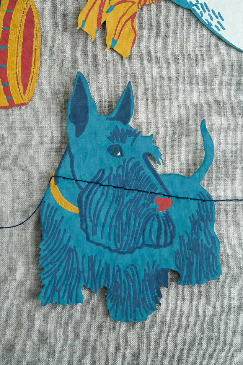 Hand-stitched blue paper Scottie dog appliqué.