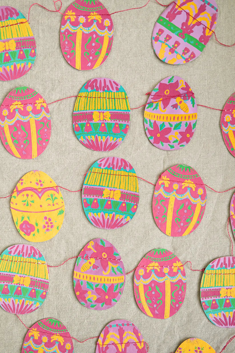 Colorful Easter egg garland on a textured beige background