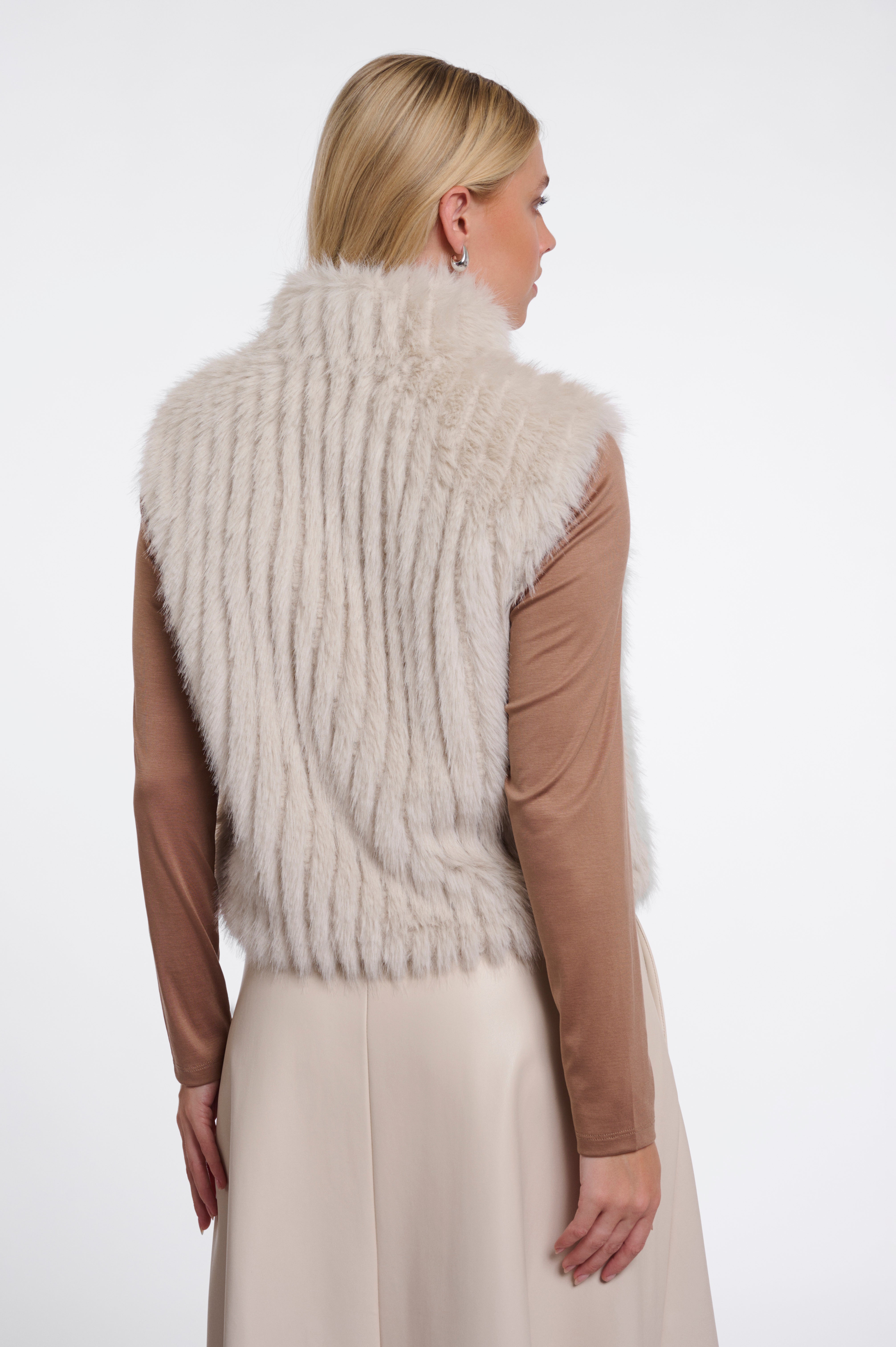 Woman wearing a white fur vest on a white background