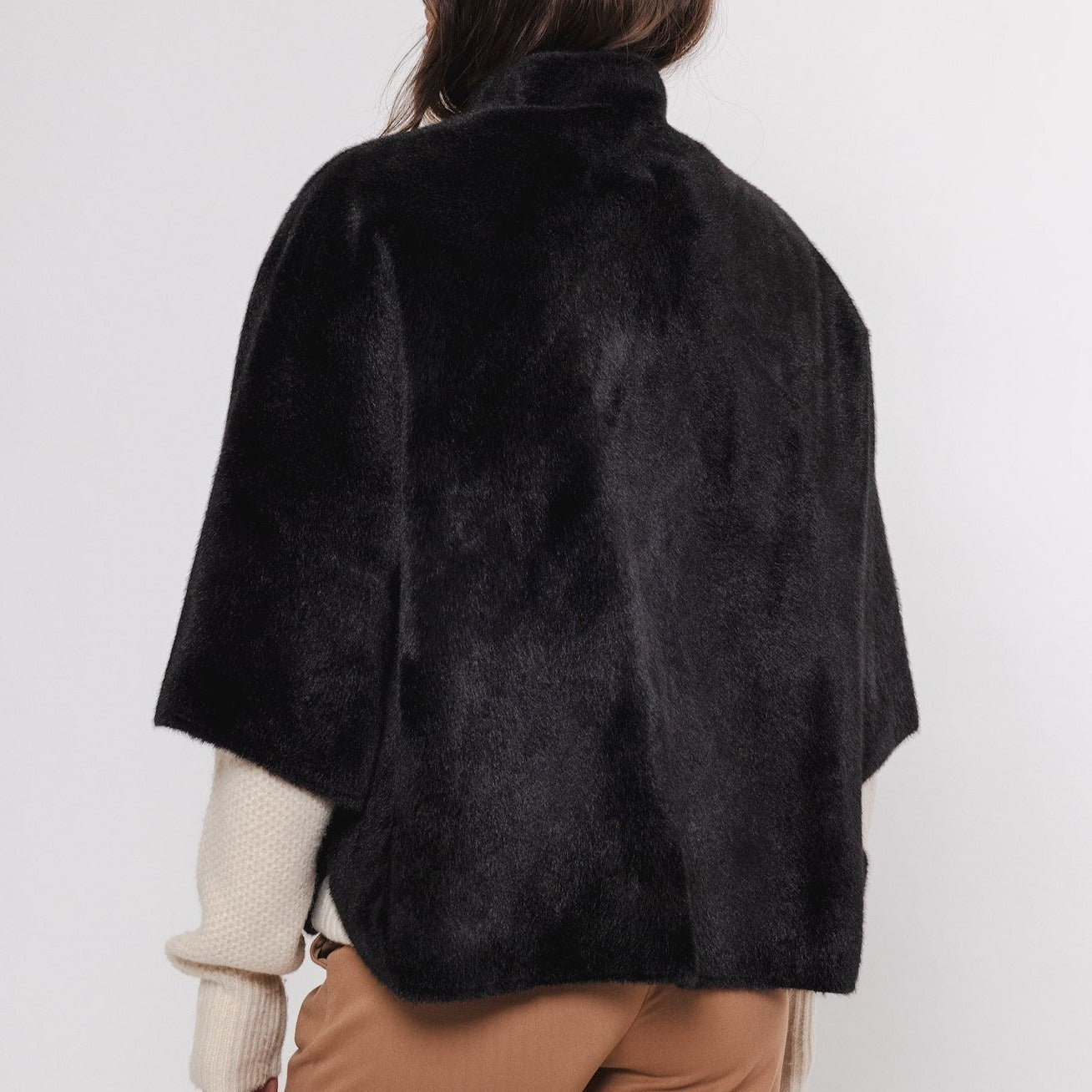Black faux fur cropped jacket with a high neck and short sleeves.