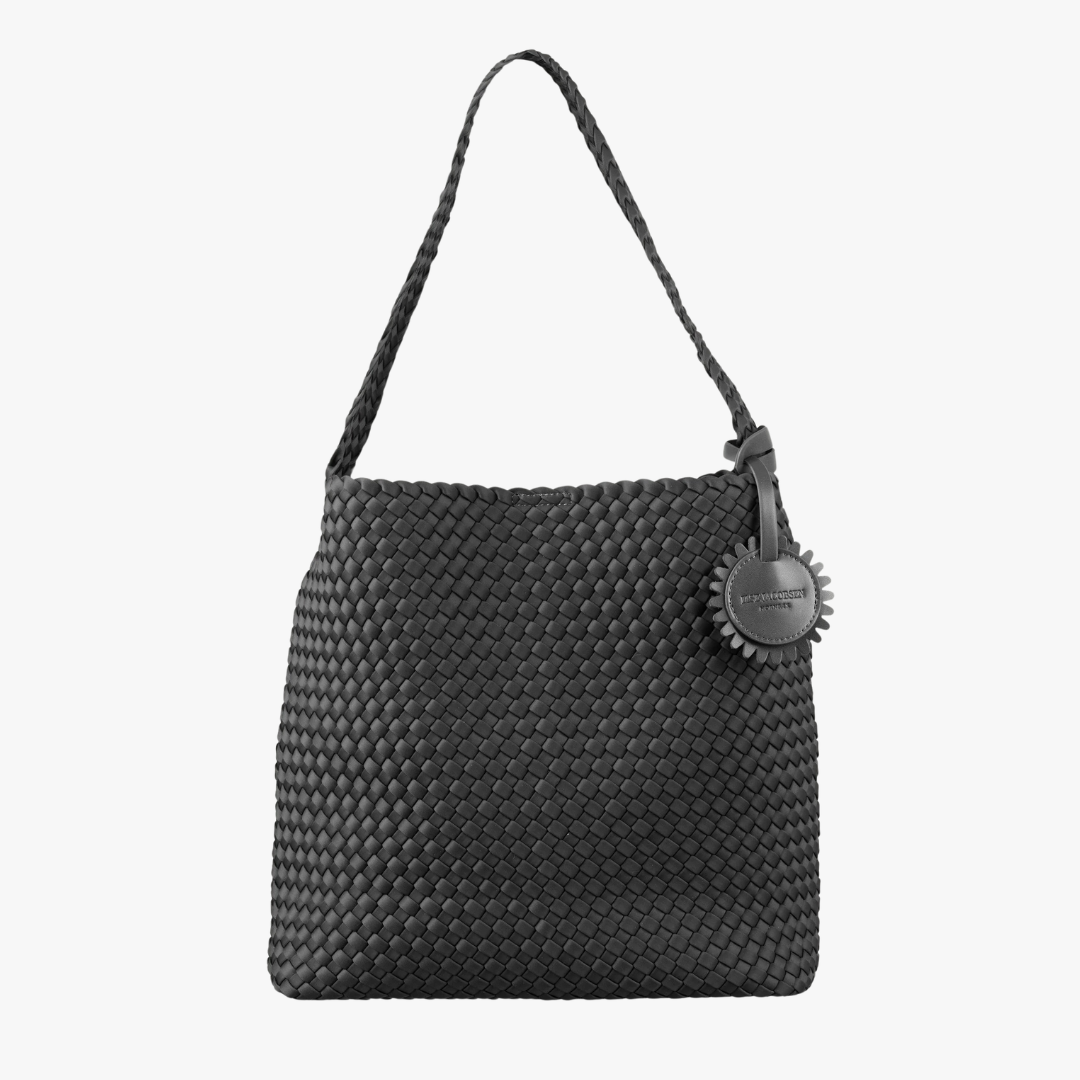 A black woven leather shoulder bag with a braided strap and a circular metal tag, shown against a plain white background.