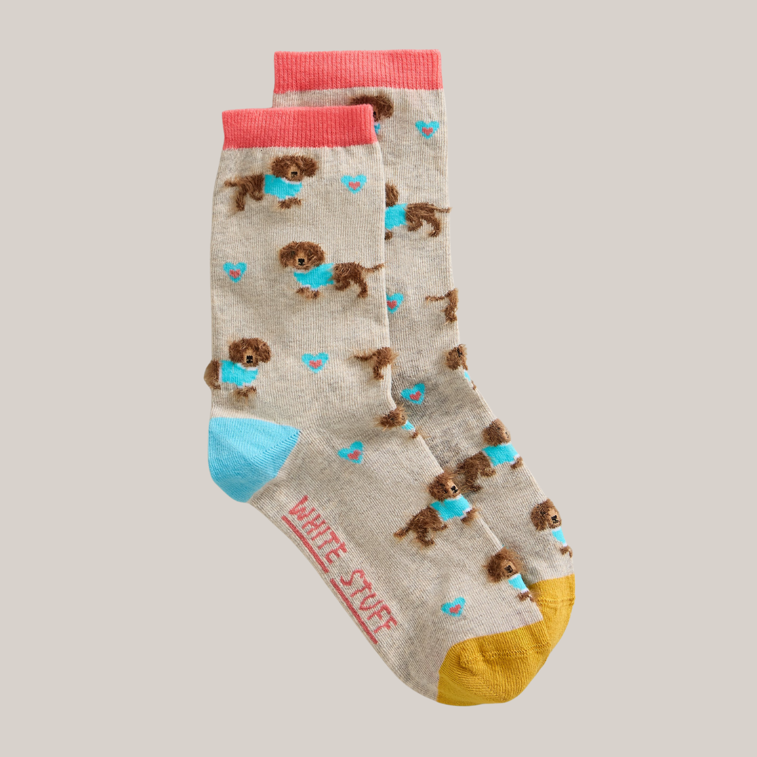 Pair of socks with dog pattern and colorful accents on a neutral background
