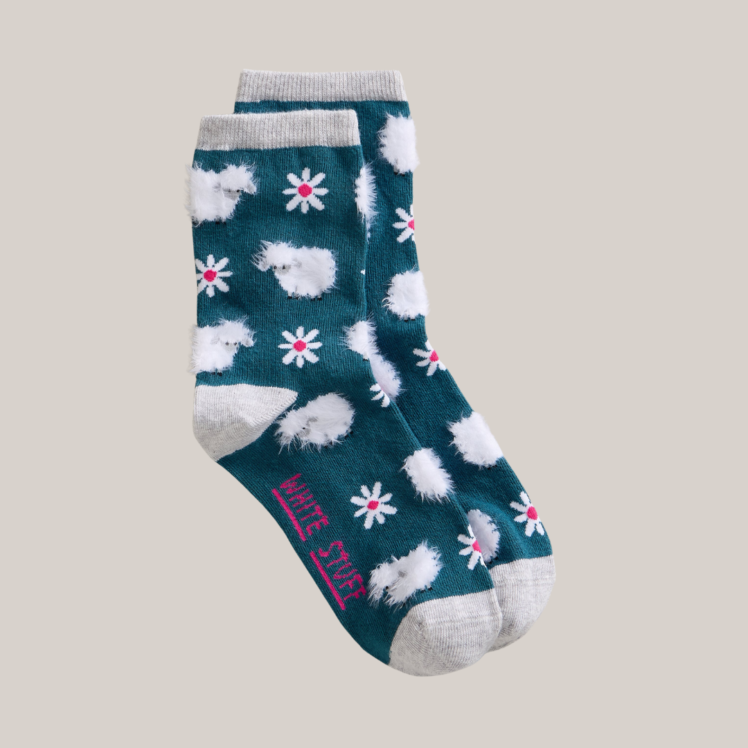 Pair of socks with hedgehog and flower pattern on a beige background