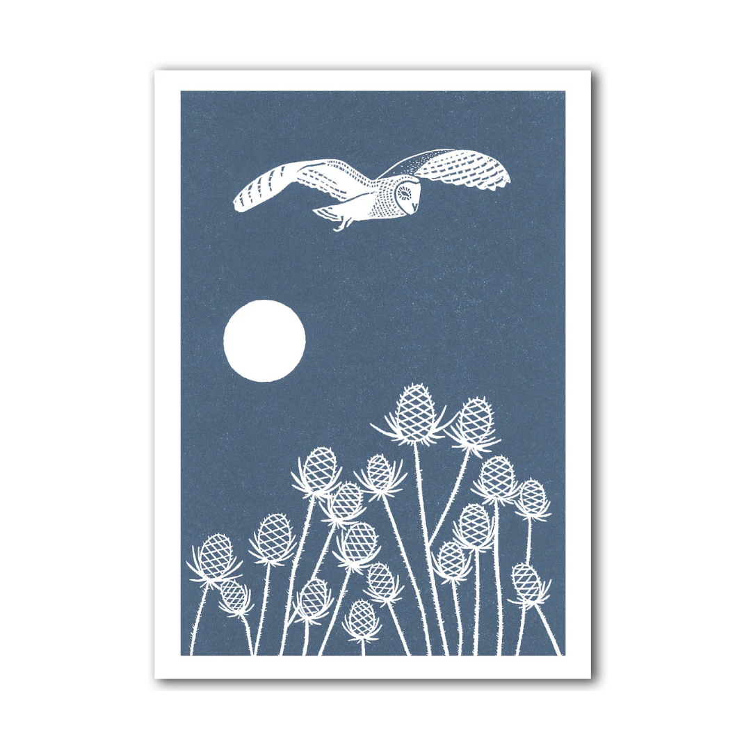 Framed artwork with a white owl flying over white flowers on a blue background