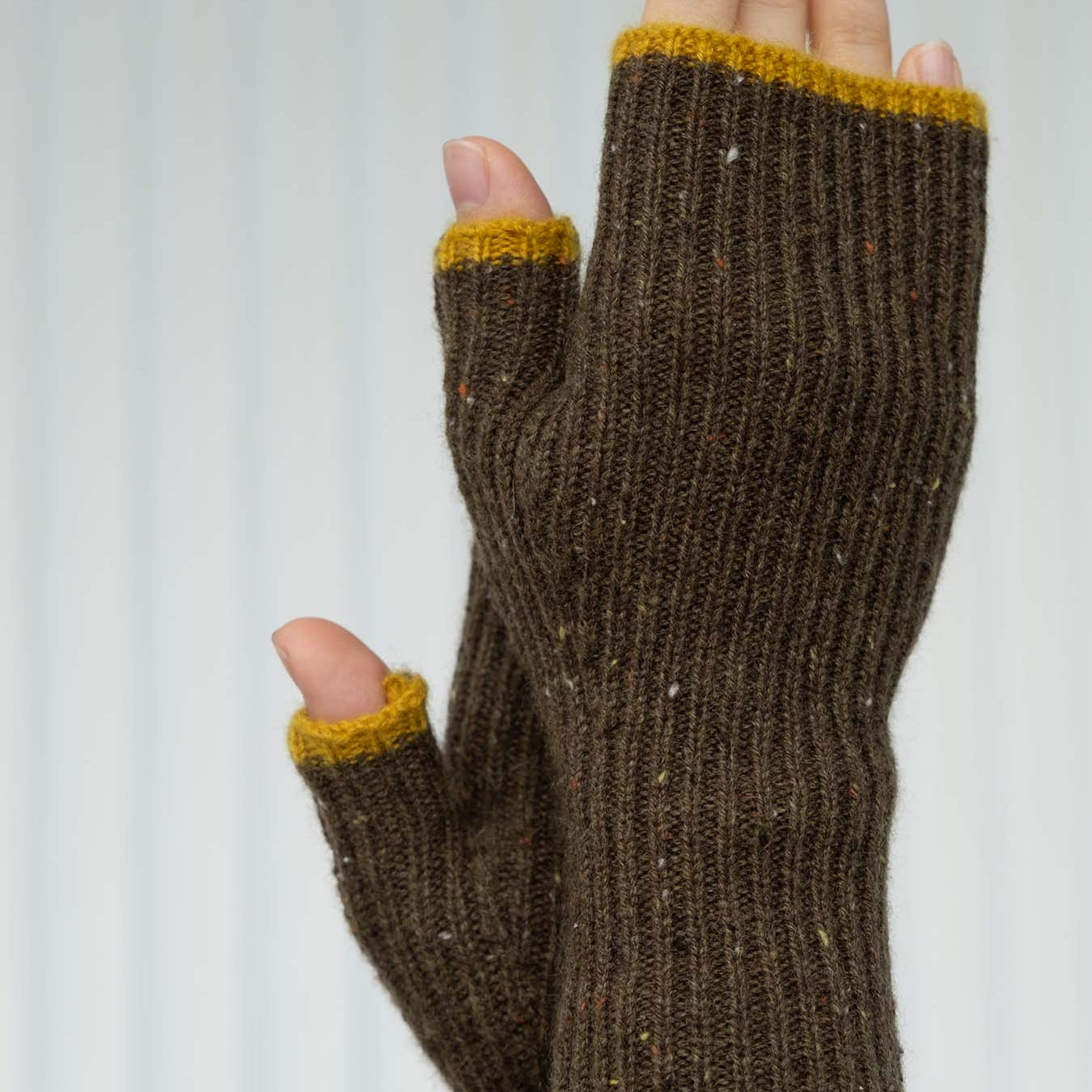 Brown fingerless gloves with yellow cuffs on a white background