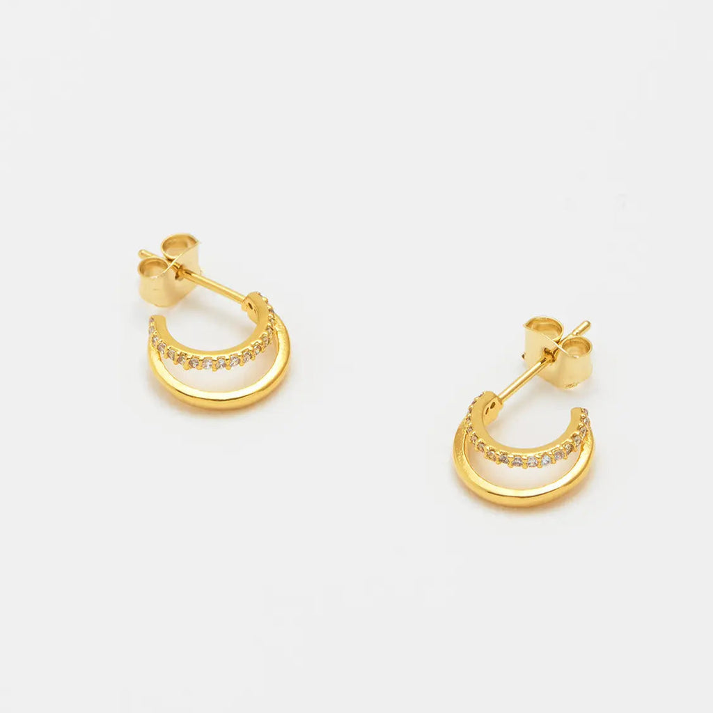 Gold double hoop earrings with small clear stones along the inner hoop.