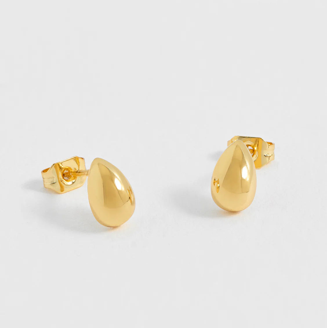 Gold hoop earrings on a light gray background