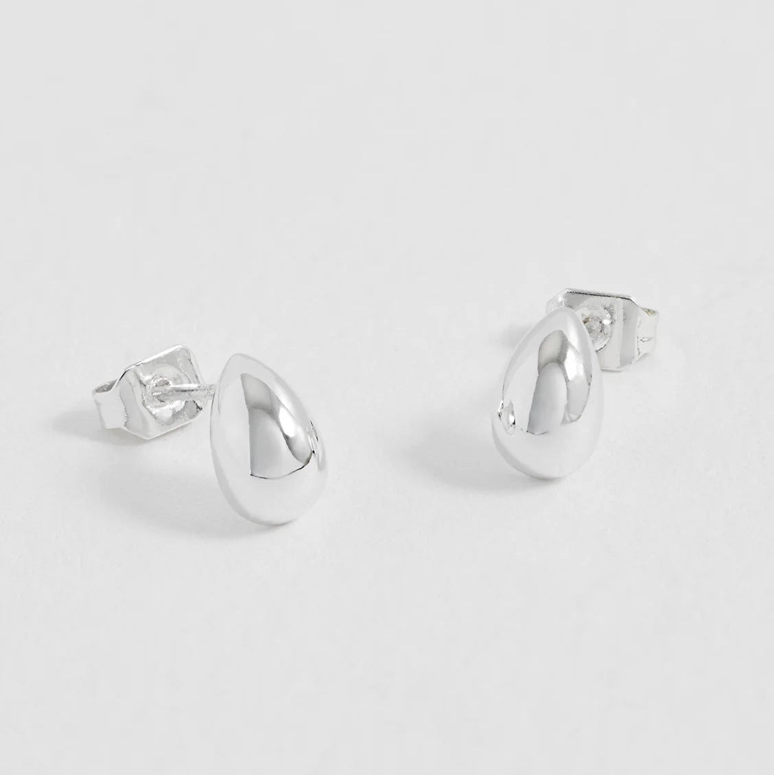 Pair of silver hoop earrings on a light gray background
