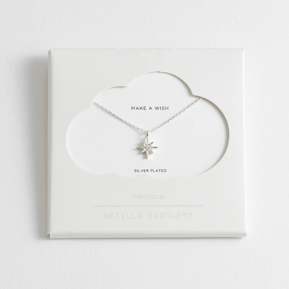 Silver-plated necklace featuring a starburst pendant with a small central stone.  "Make a Wish" necklace by Estella Bartlett.