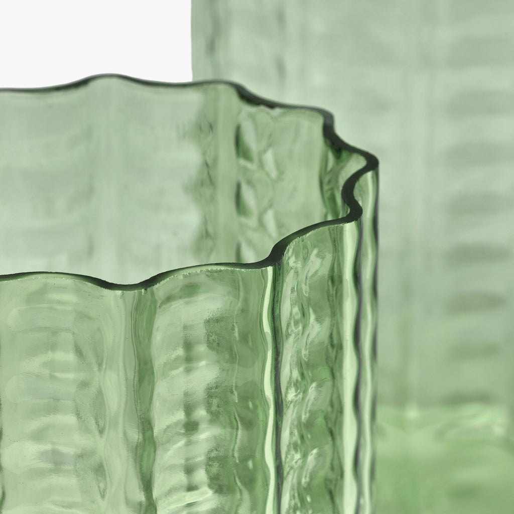 close up of a light green, mouthblown glass vase, from the WAVE collection, designed by interior and furniture designer Ruben Deriemaeker, for Belgian design brand Serax.