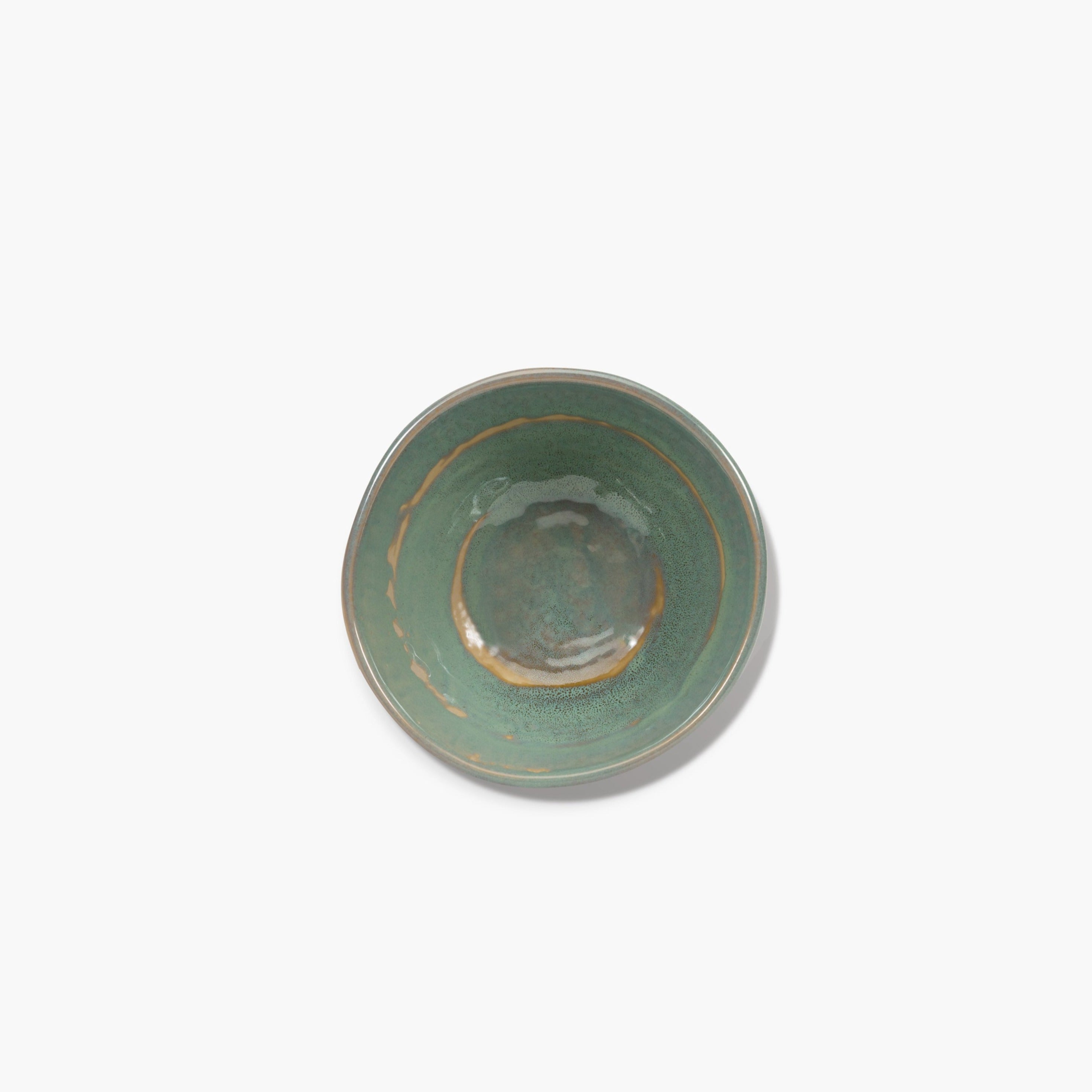 Overhead view of a teal ceramic bowl with a speckled texture and a darker rim.