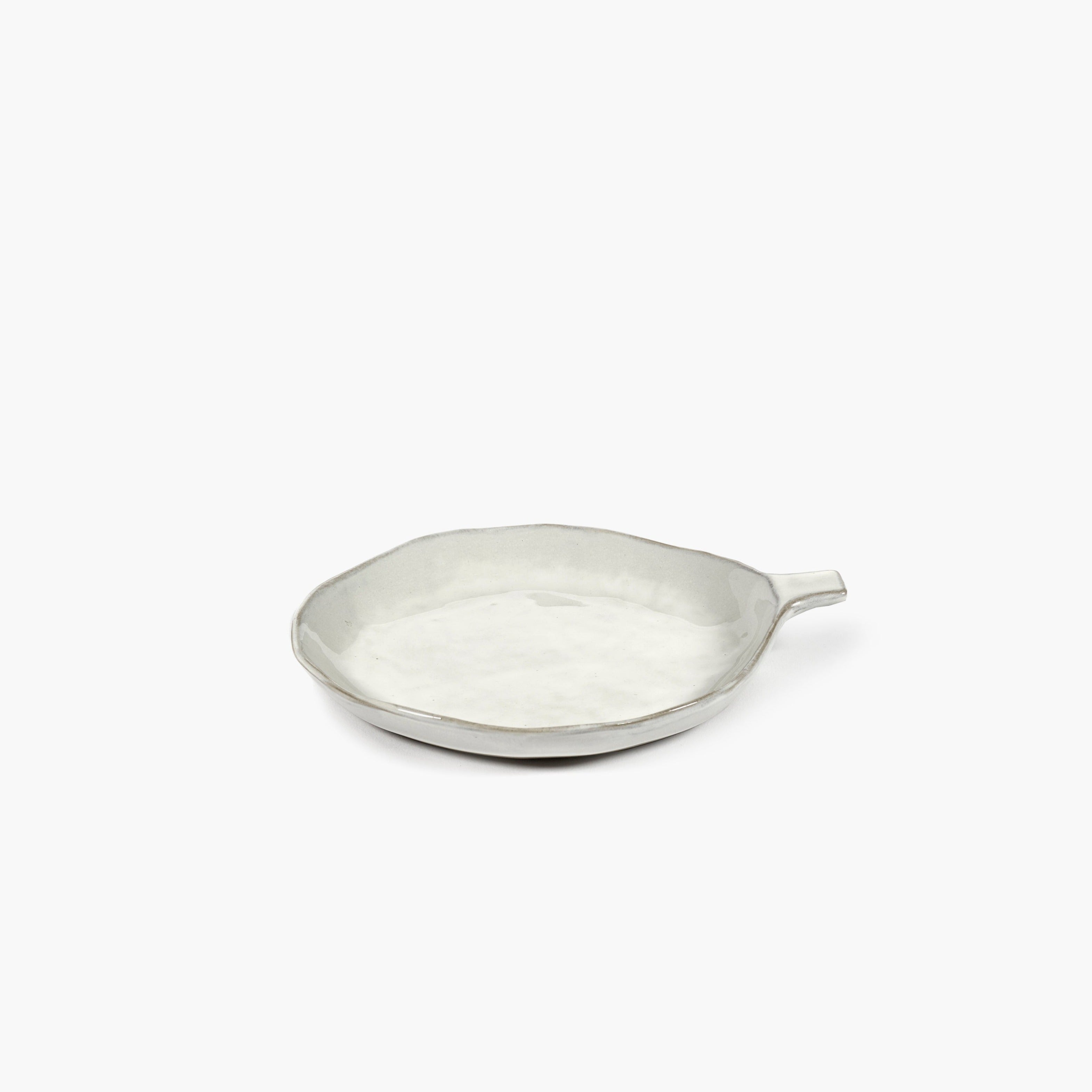 Off-white ceramic serving dish with an irregular shape and a small handle.