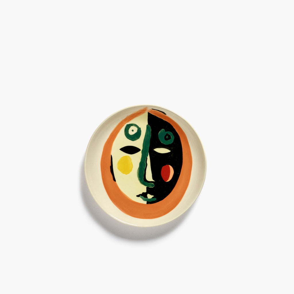 plate with a painting of a face in black, orange and green, from the FEAST collection, designed by British-Israeli chef Yotam Ottolenghi, for Belgian design brand Serax.