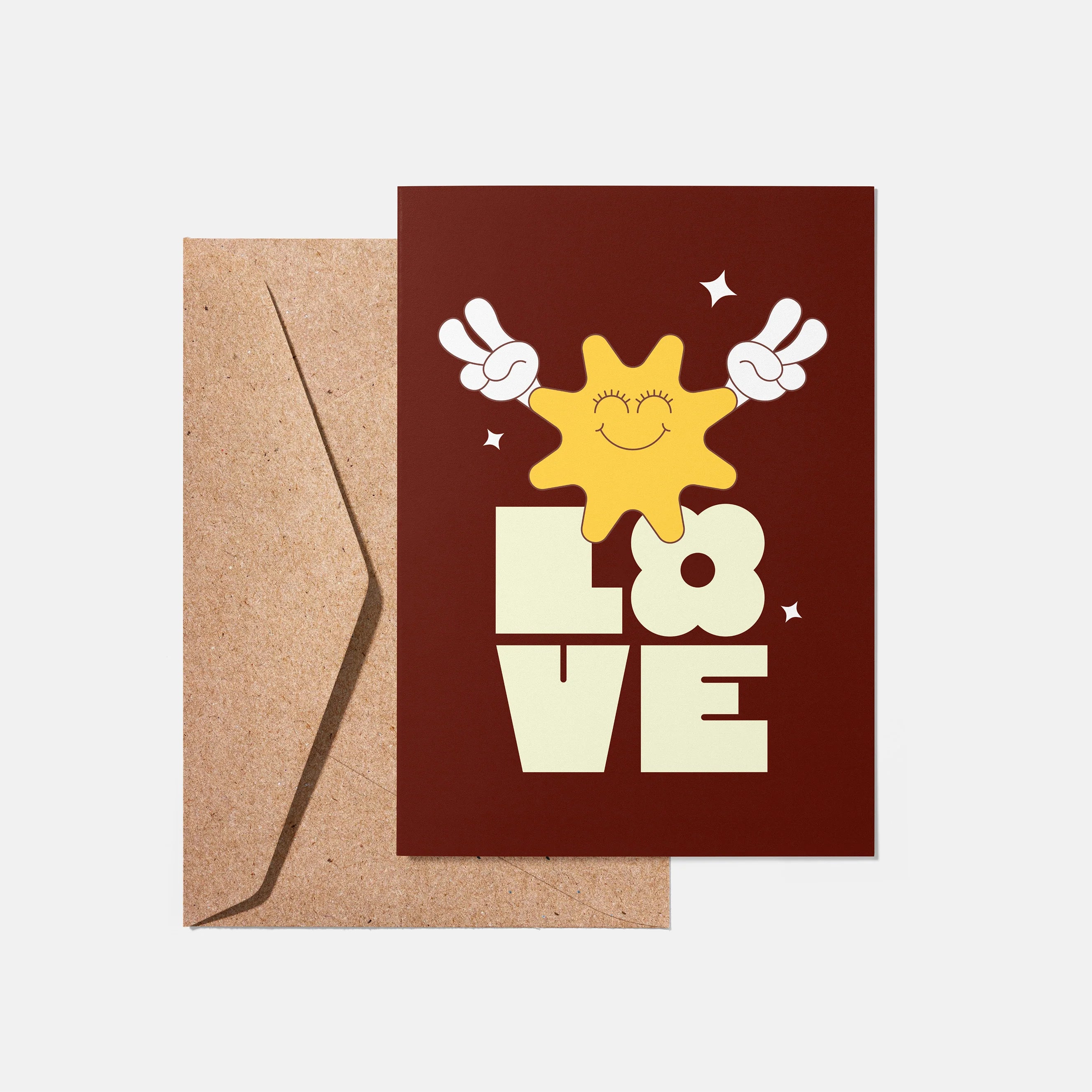Greeting card with a sun and 'LOVE' text on a brown background with a kraft envelope.