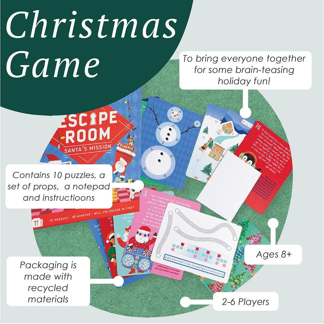 Christmas Game activity kit shown as a flat lay with labeled callouts on a light gray background. The set includes a dark green 'Christmas Game' title panel, a round green play mat, puzzle cards, Santa-themed cards, snowman cards, a notepad, and other holiday-themed pieces.