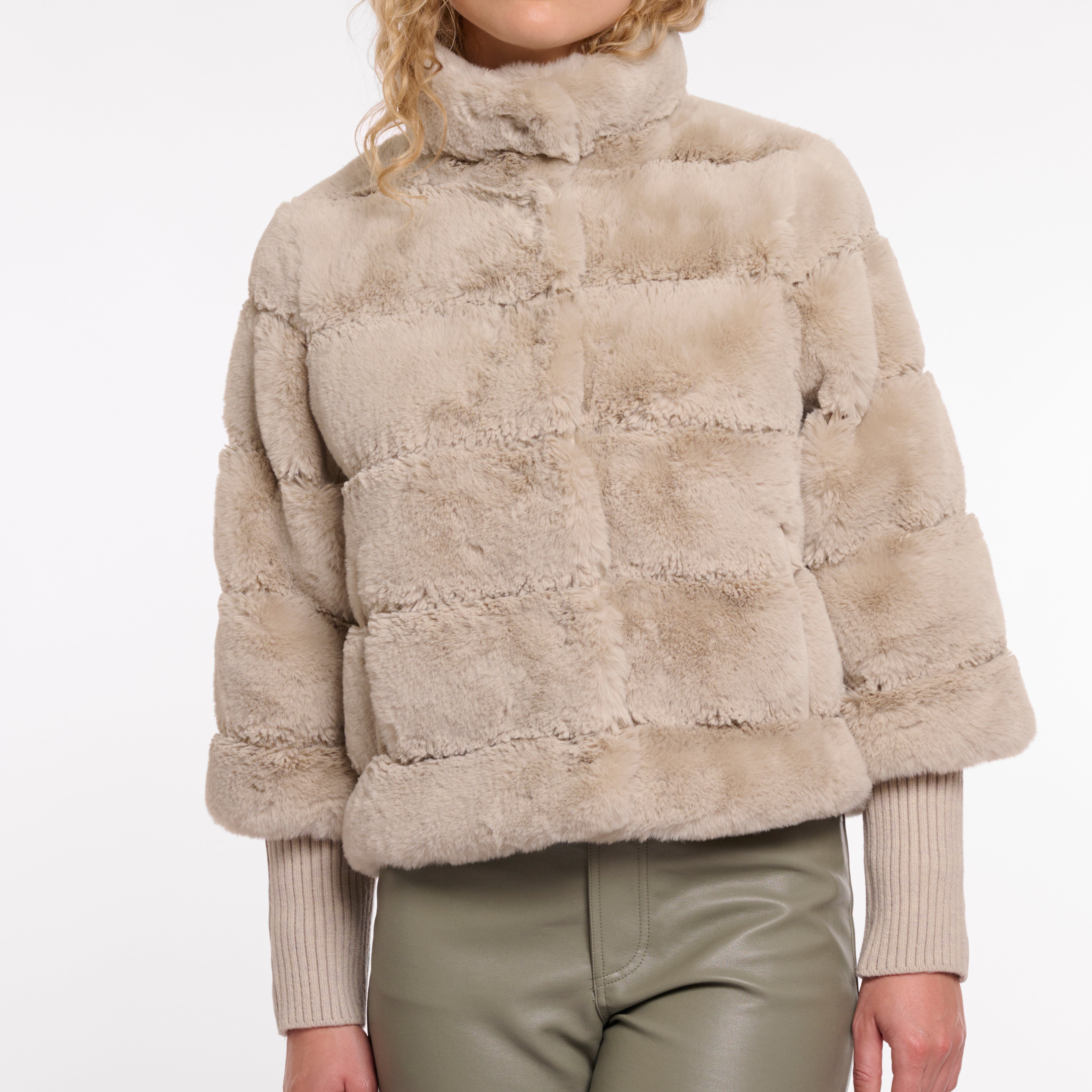 Beige faux fur jacket worn by a person on a white background