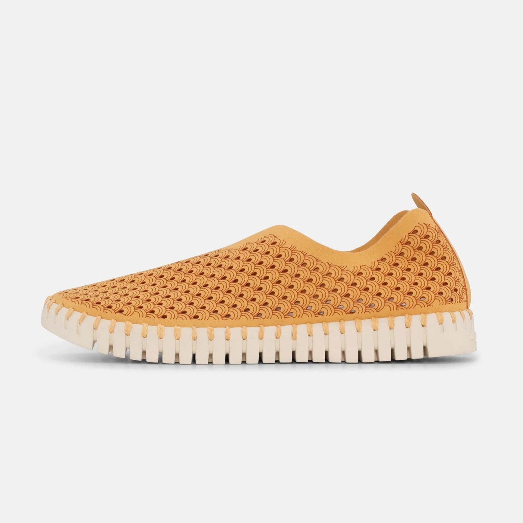 Tan slip-on shoe with a textured, wave-patterned upper and off-white, ridged sole.
