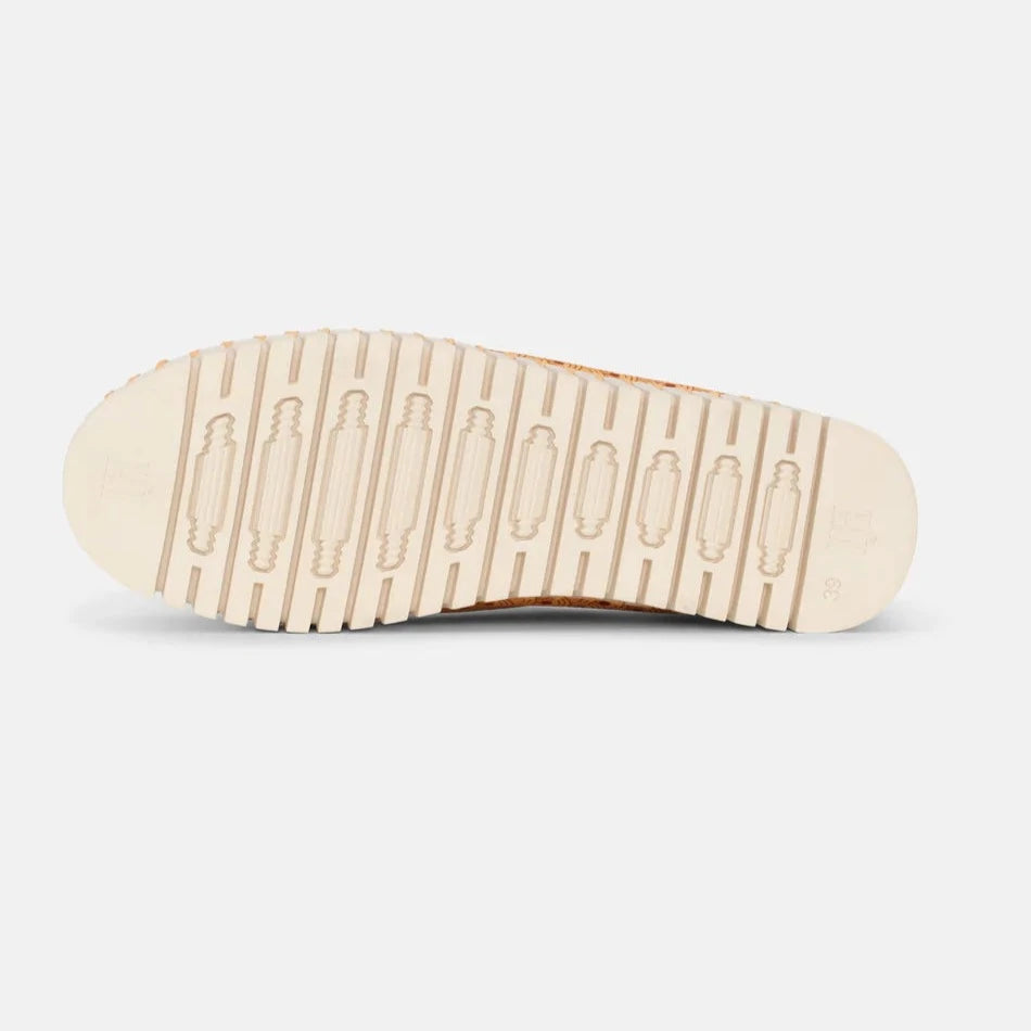 Beige cork-textured shoe sole with off-white, patterned tread.