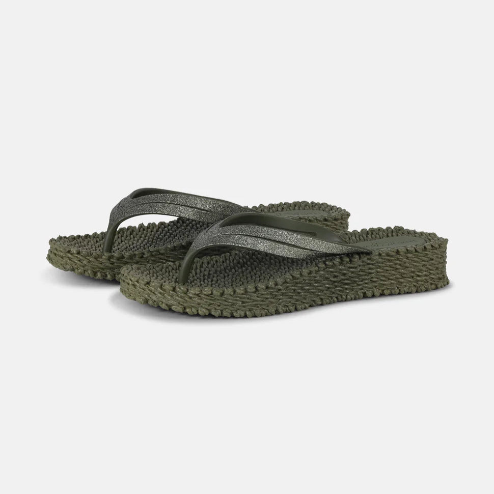 Olive green glitter flip-flops with textured soles and slightly elevated heels.
