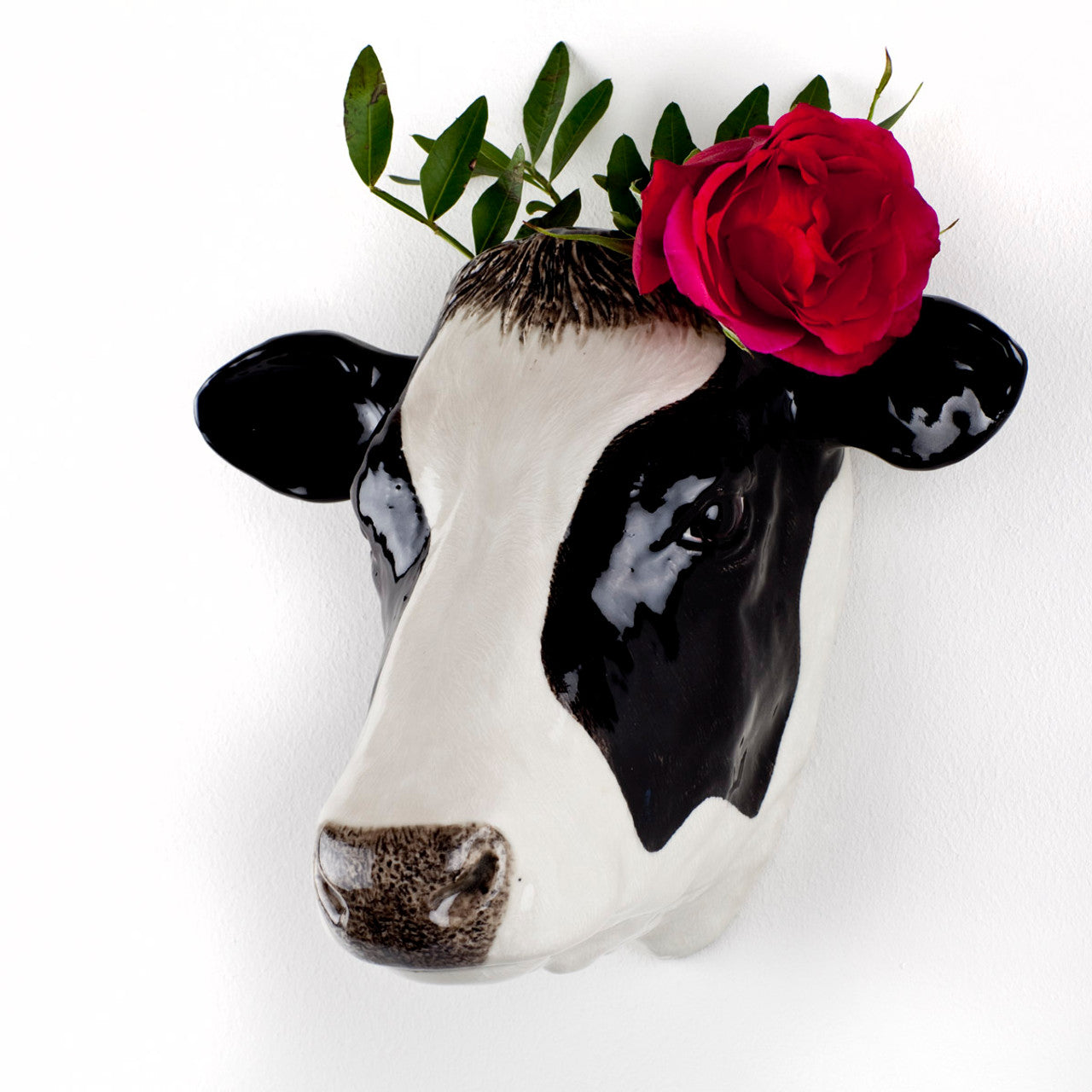 Black and white ceramic cow head wall vase, decorated with a red rose.