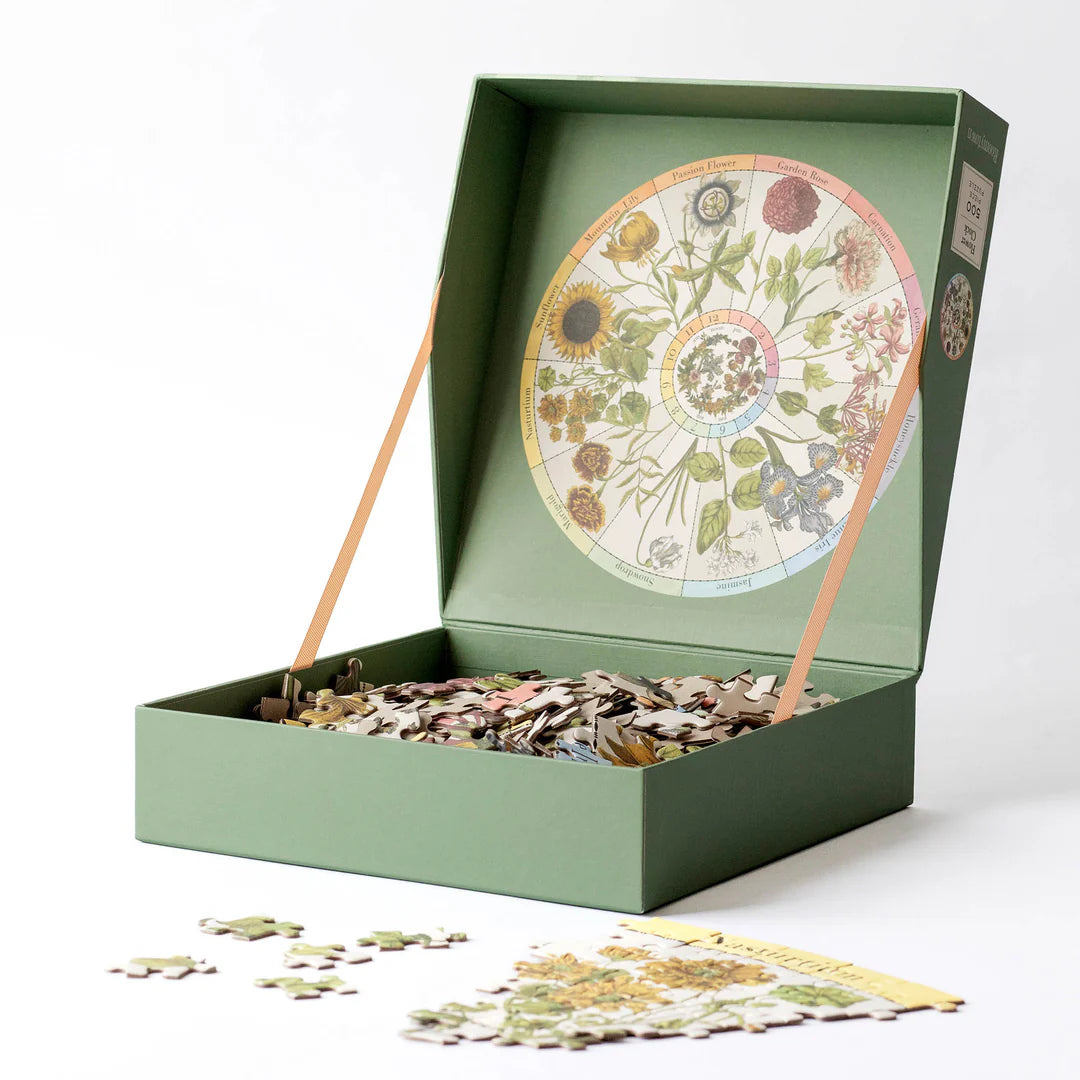 Floral puzzle in a green box with scattered pieces on a white background