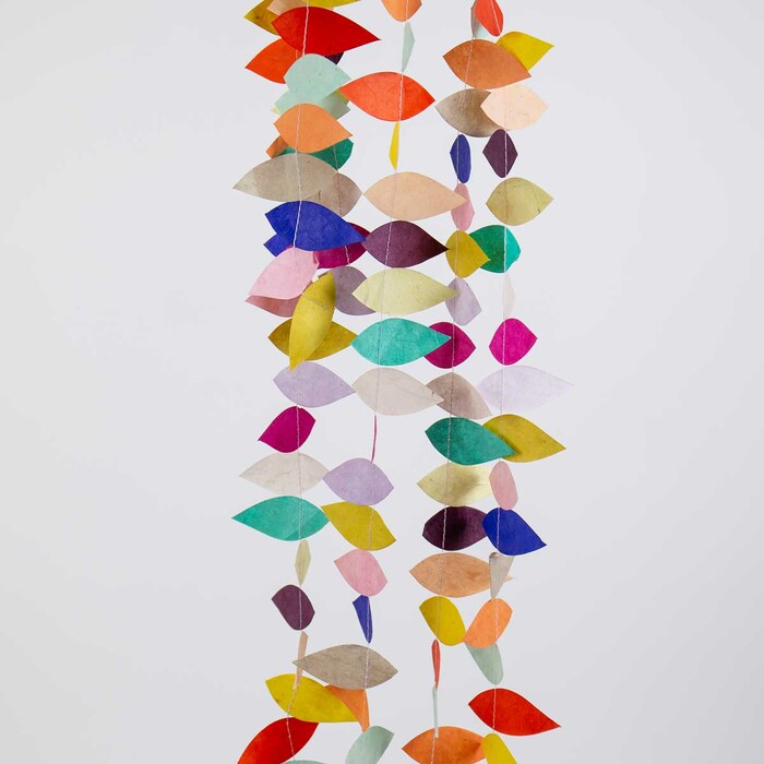 Colorful leaf-shaped paper hanging against a white background