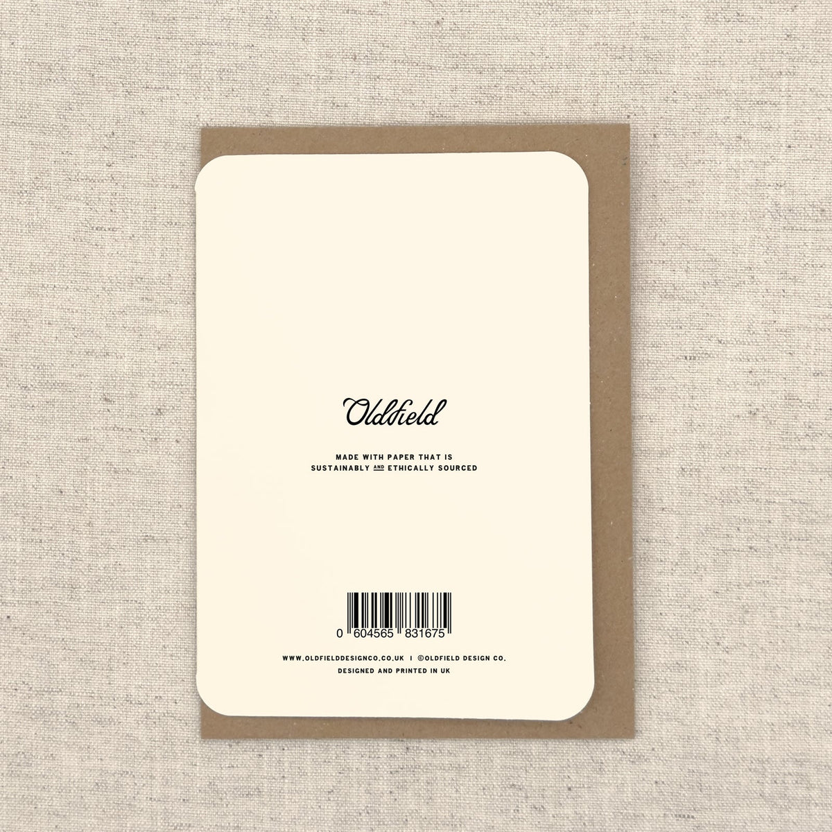 Back of a greeting card with 'Oldfield' branding and sustainability information on a textured beige background.