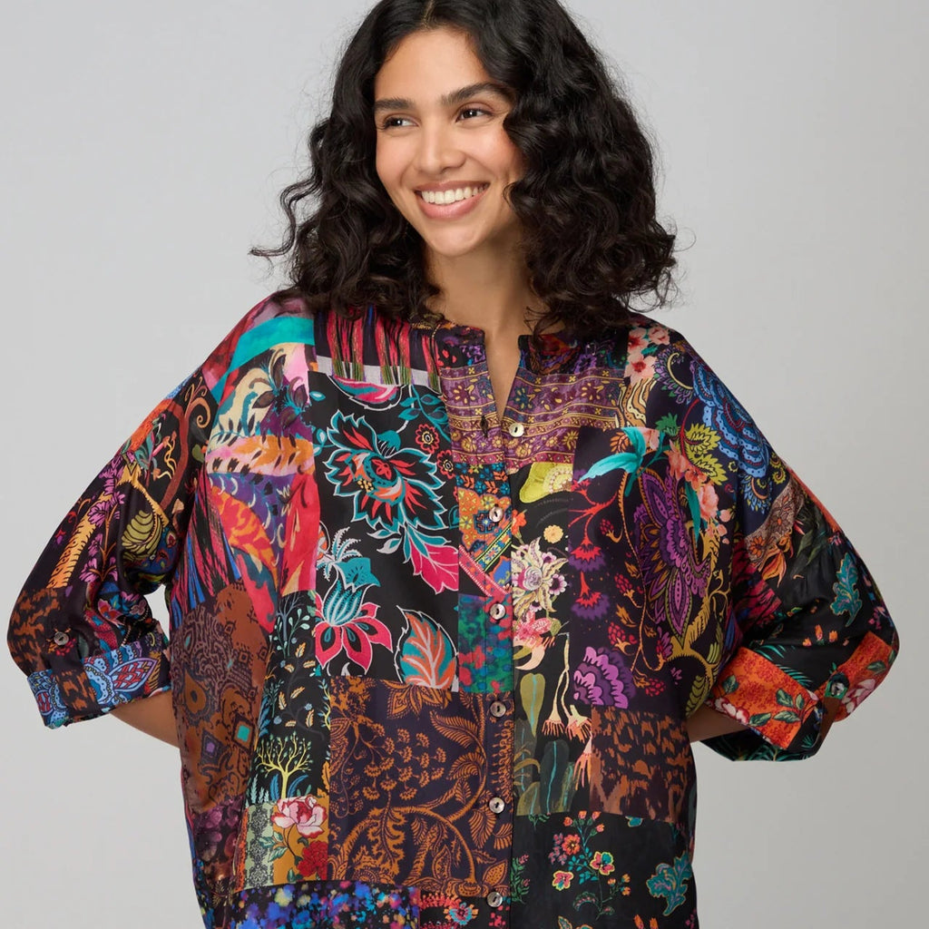 Woman wearing a colorful patterned shirt against a plain background