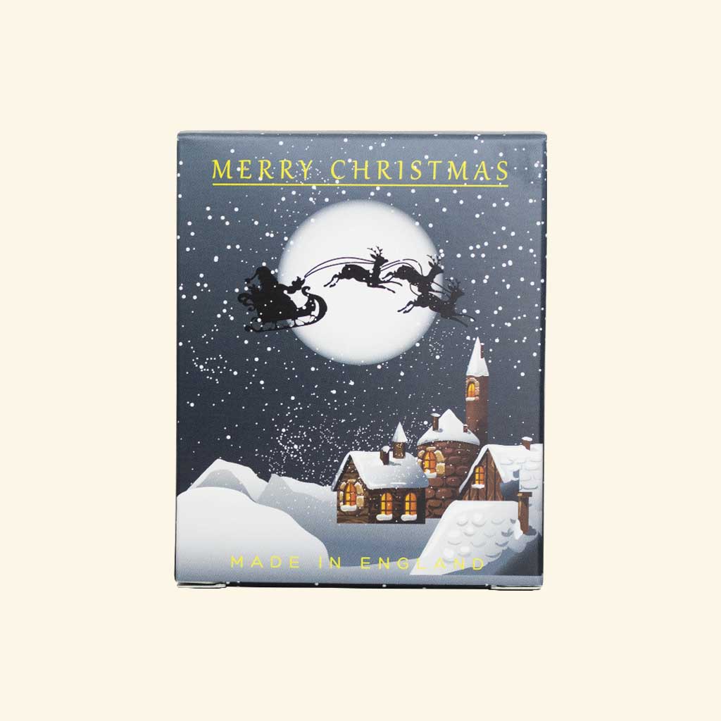 Christmas-themed box featuring Santa's sleigh and reindeer flying across a snowy village scene under a full moon.