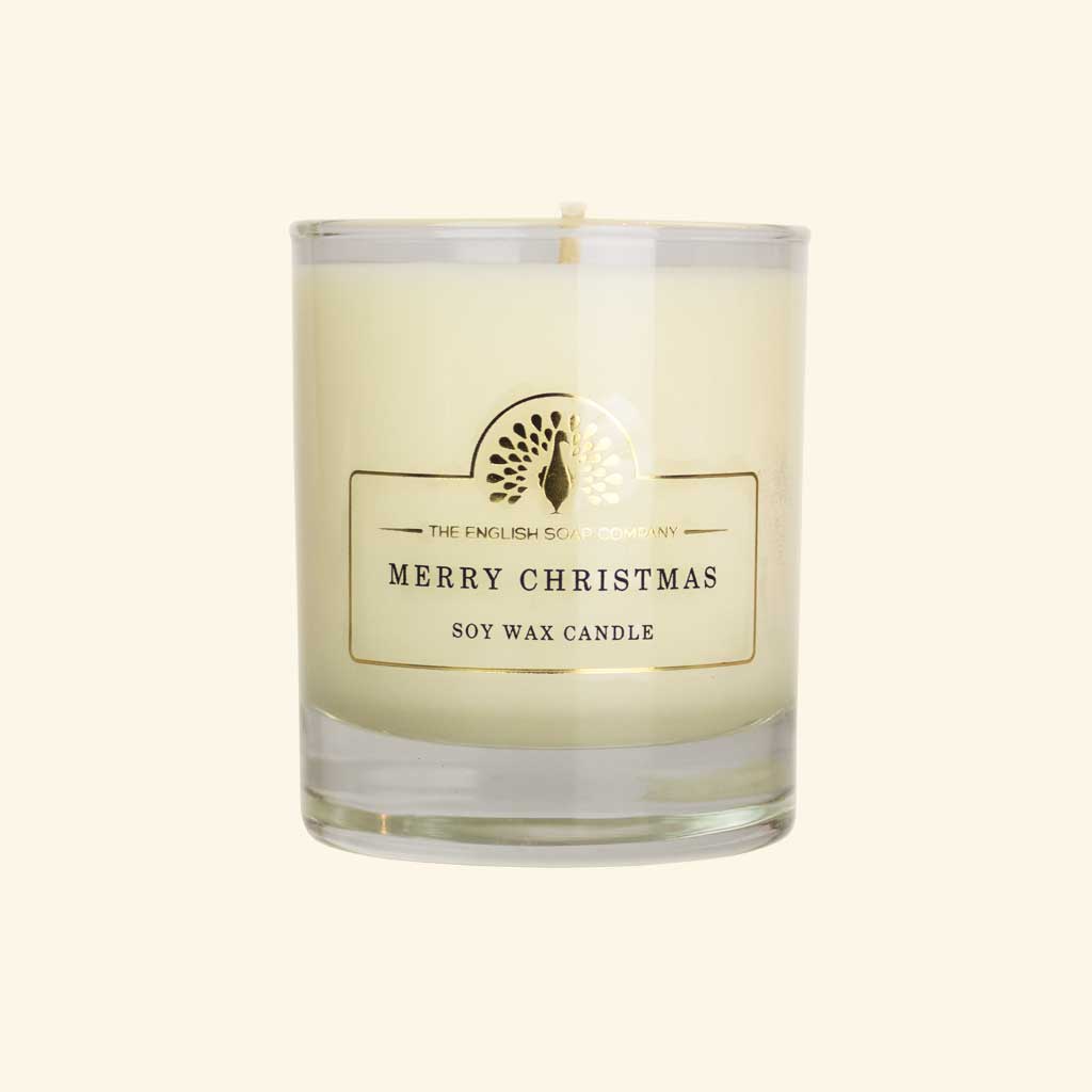 Merry Christmas soy wax candle in a clear glass jar with a gold label featuring The English Soap Company logo.