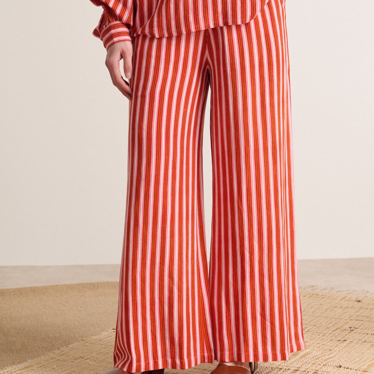 Wide-leg pants with vertical red and pink stripes.