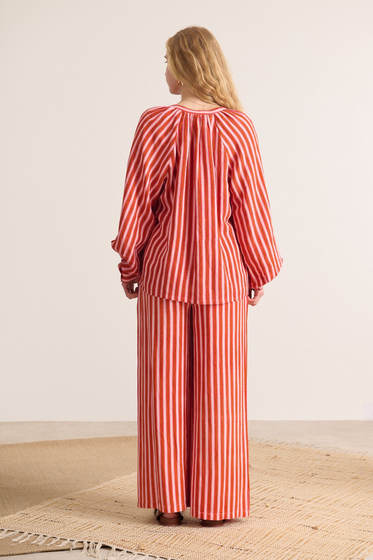 Red and pink striped wide-leg pants and matching blouse.  The top has a V-neck and balloon sleeves.