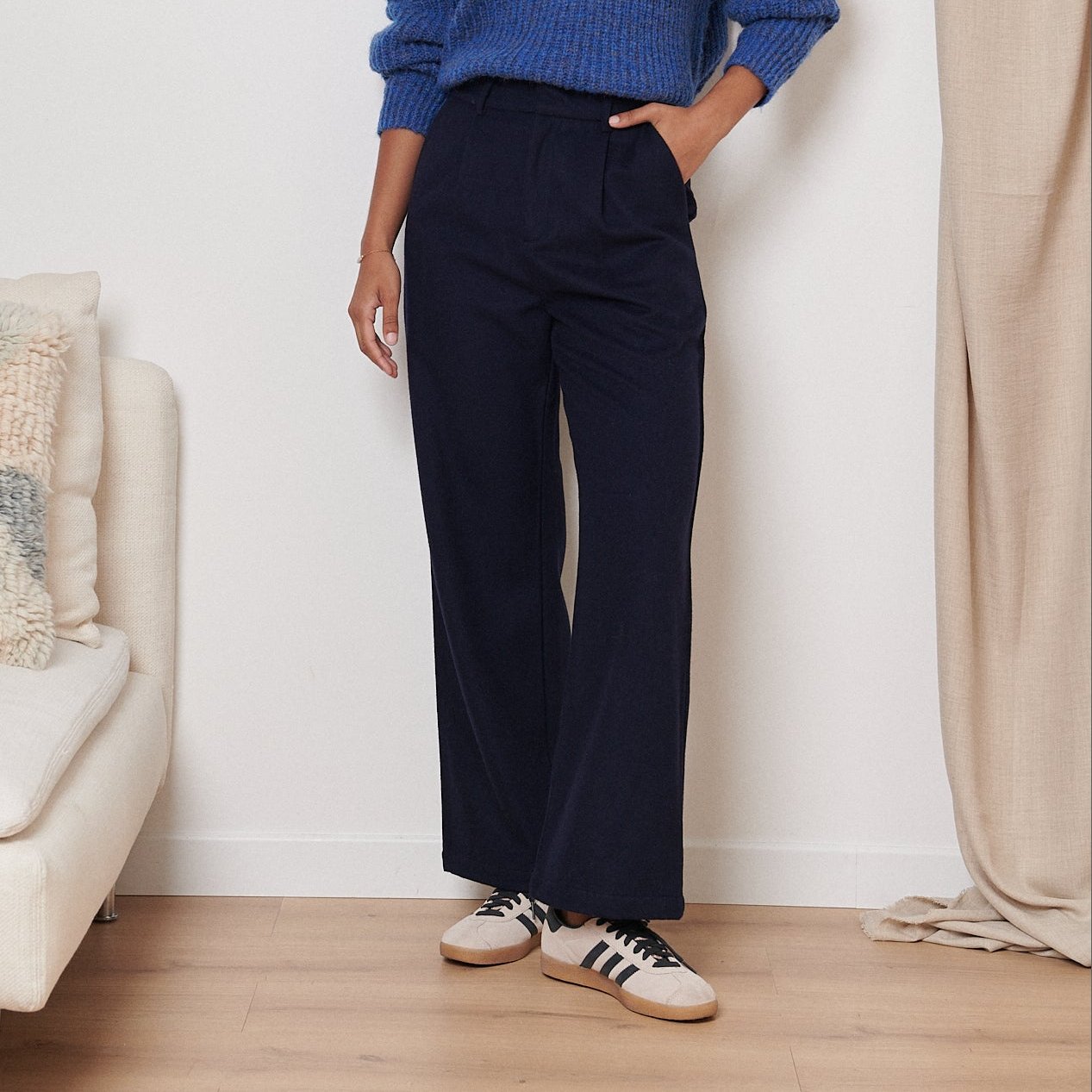 Navy blue high-waisted wide-leg pants with a pleated front.