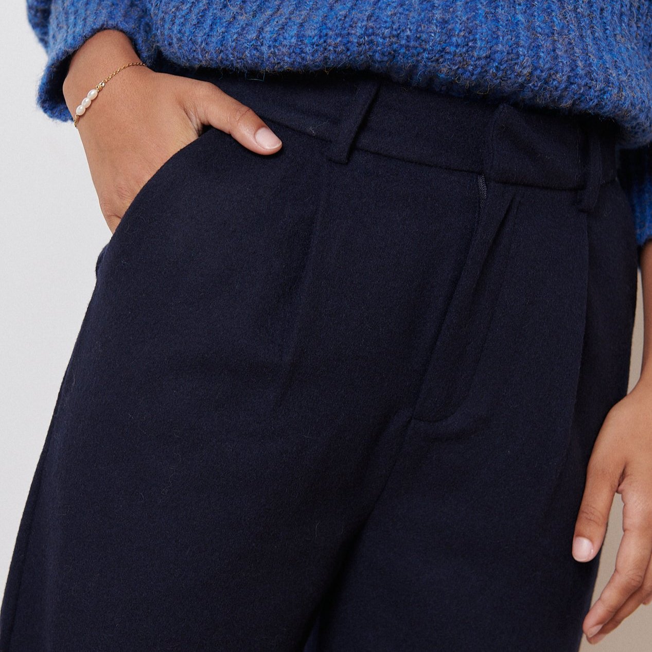 Dark navy blue wool trousers with a high waist and front pockets.