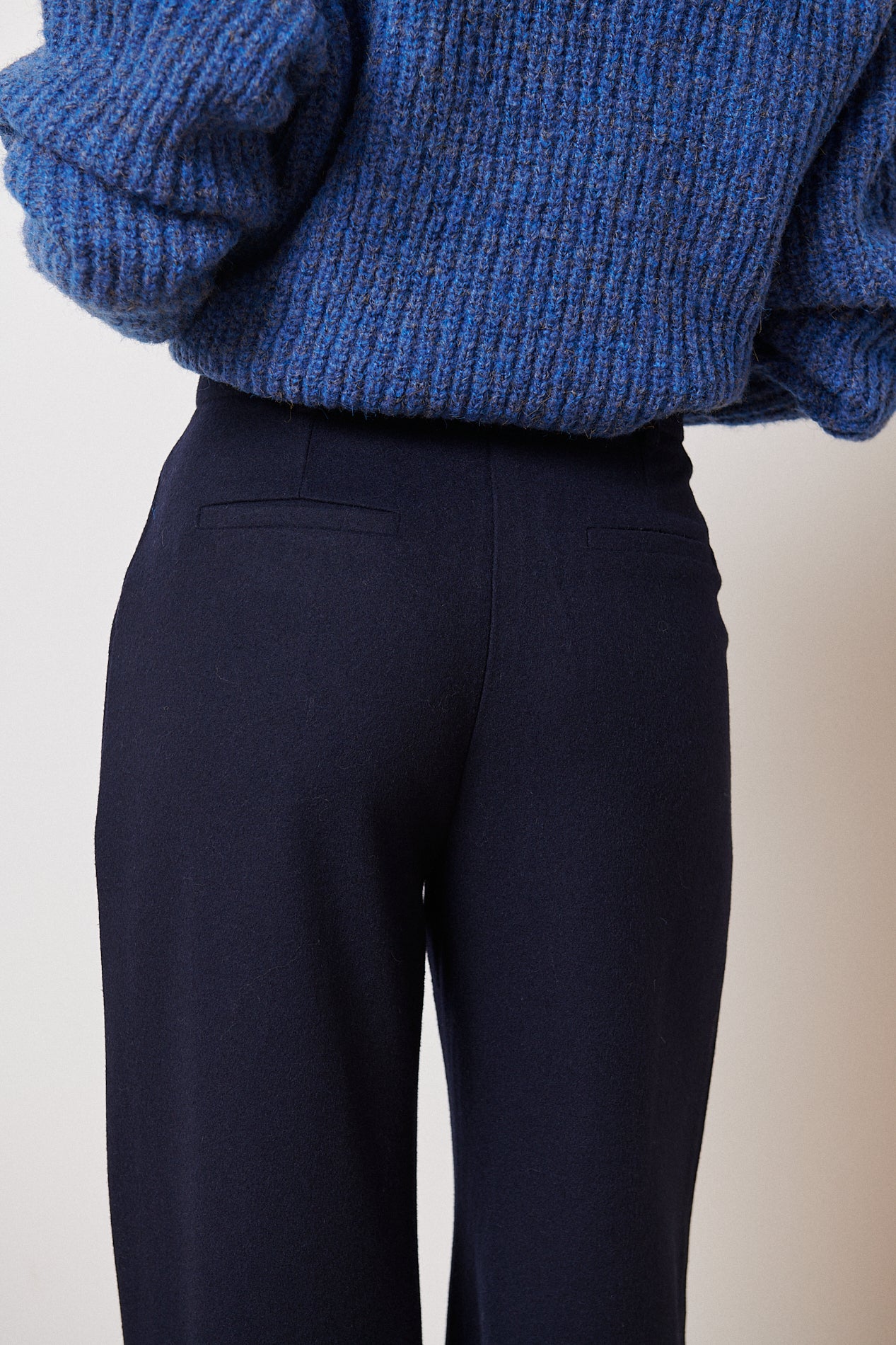 Dark navy blue high-waisted wide-leg trousers; back view showing pockets.