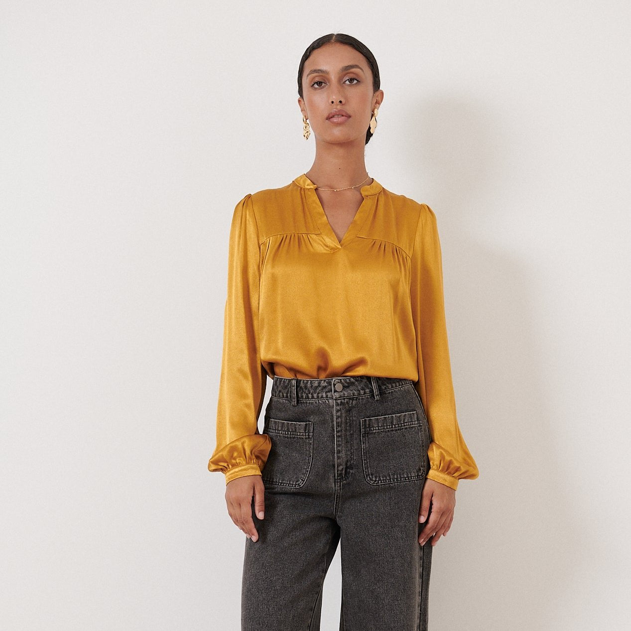 Mustard yellow satin blouse with long sleeves and a V-neck.