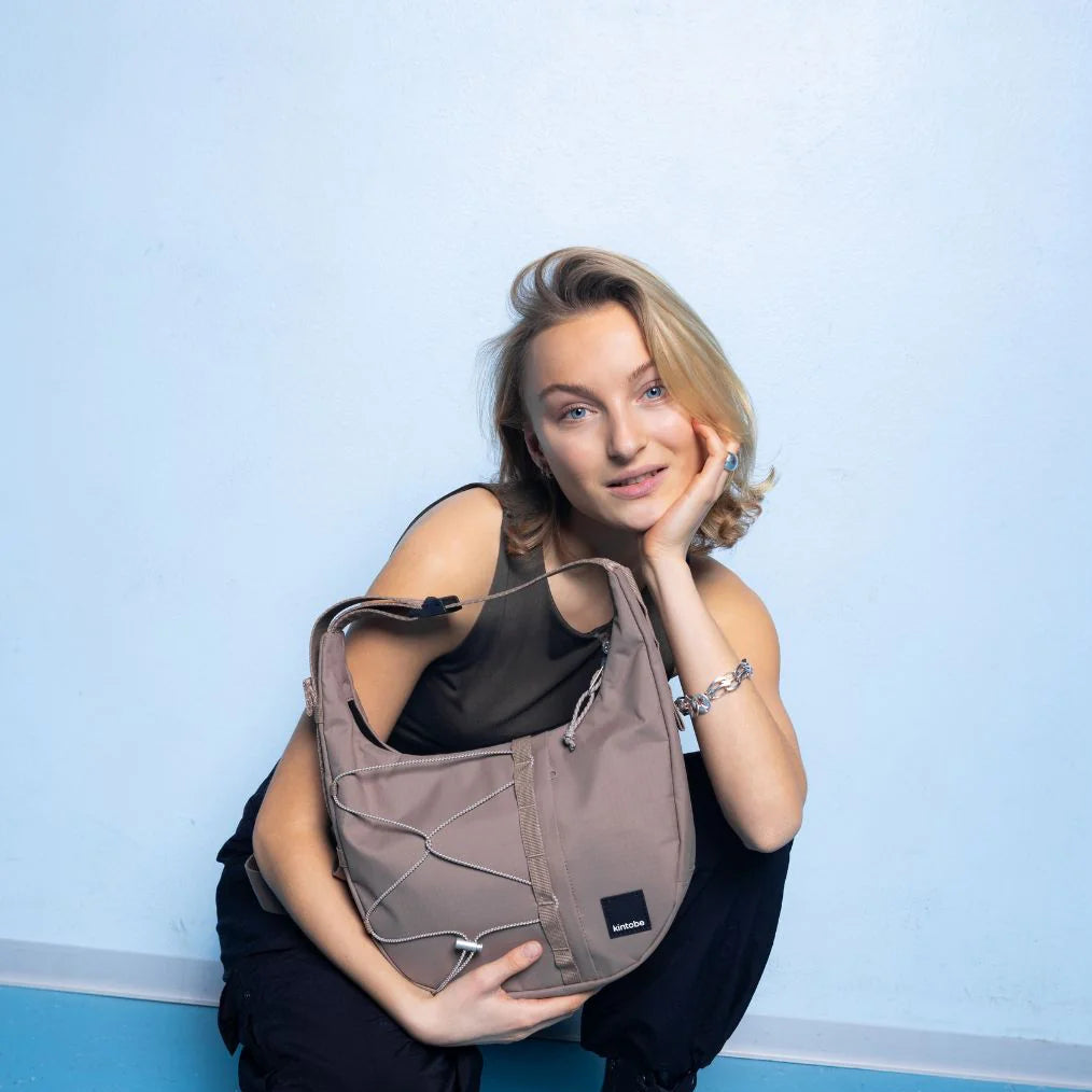 Taupe Kurio crossbody bag with adjustable strap and silver hardware.