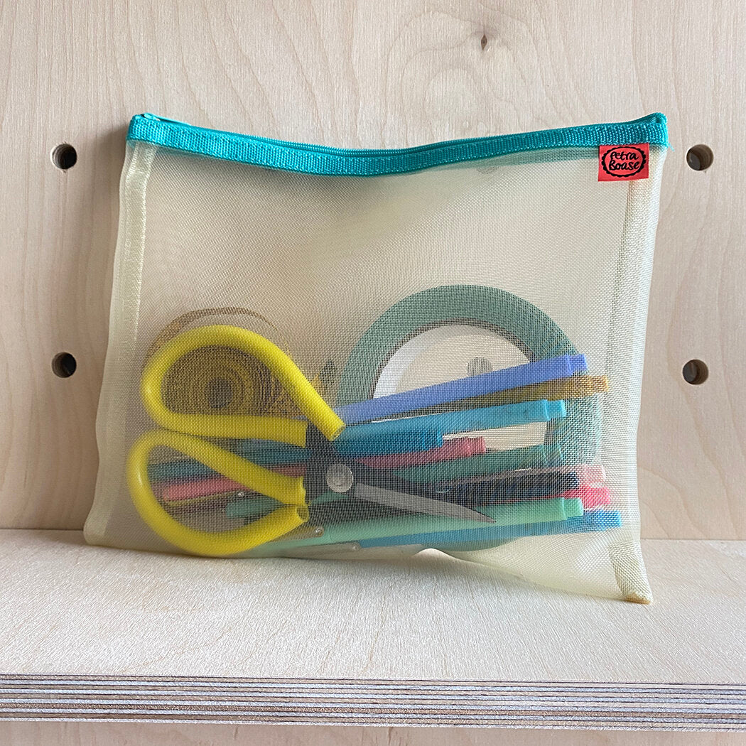 Pale yellow mesh zipper pouch with teal zipper, containing yellow scissors, colorful pens, and rolls of tape.